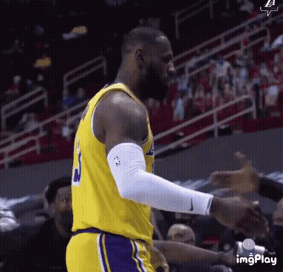 A Basketball Player Wearing A Yellow Jersey With The Number 3 On It Is Standing In Front Of A Crowd . GIF