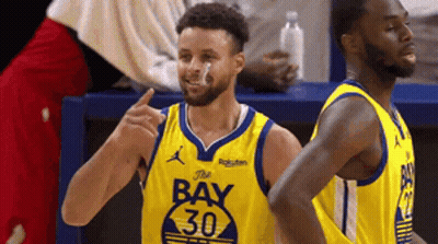 A Basketball Player Wearing A Yellow Jersey With The Number 30 On It Is Standing Next To Another Player . GIF