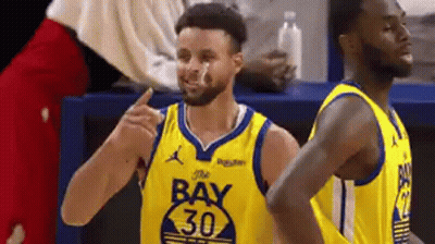 A Basketball Player Wearing A Yellow Jersey With The Number 30 On It Is Standing Next To Another Player . GIF