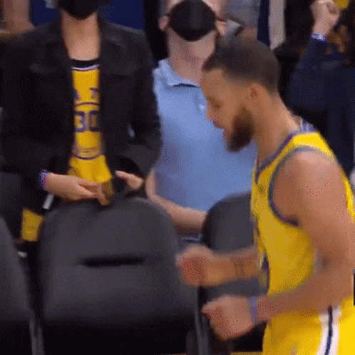 A Basketball Player Wearing A Yellow Jersey With The Number 30 On It Stands In Front Of A Crowd . GIF