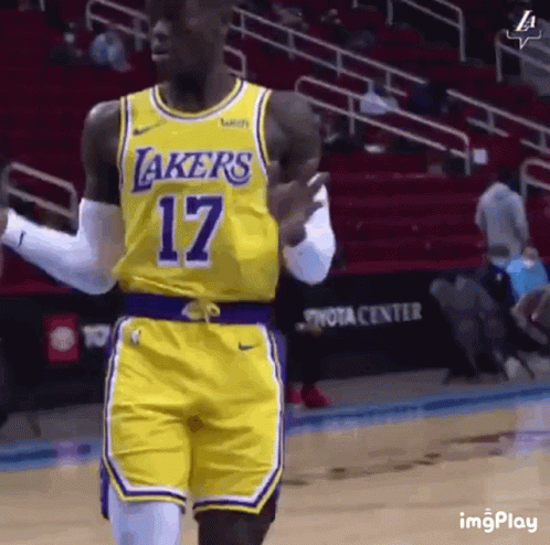 A Basketball Player Wearing A Yellow Lakers Jersey And Shorts Is Walking On The Court . GIF