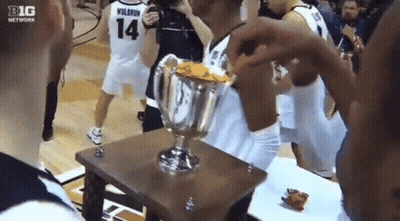 A Basketball Player Wearing Number 14 Holds A Trophy GIF