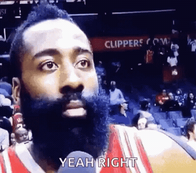 A Basketball Player With A Beard Is Talking Into A Microphone While Sitting In The Stands . GIF