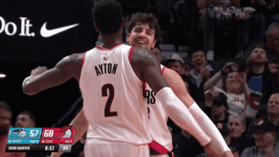 A Basketball Player With Ayton On The Back Of His Jersey Is Hugging Another Player GIF