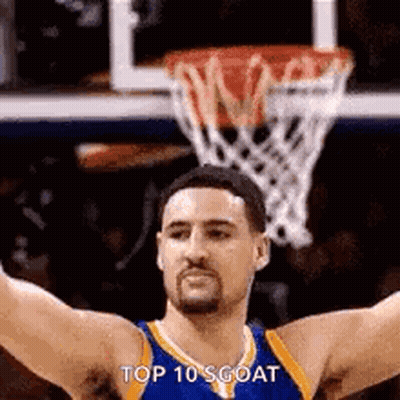 A Basketball Player With His Arms Outstretched In Front Of A Basketball Hoop . GIF