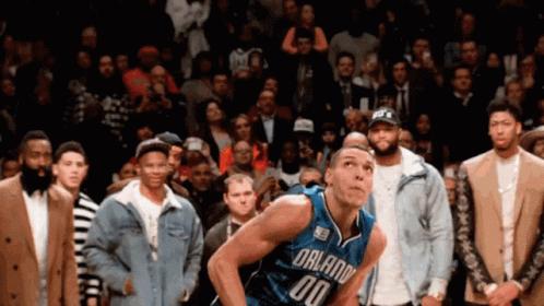 A Basketball Player With The Number 00 On His Jersey Stands In Front Of A Crowd GIF