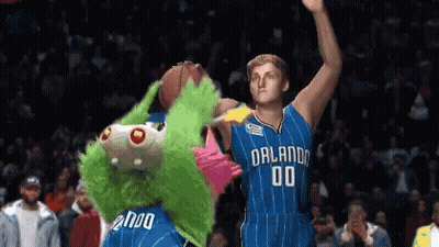 A Basketball Player With The Number 00 On His Jersey Stands Next To A Mascot GIF