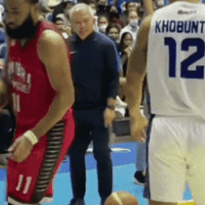 A Basketball Player With The Number 12 On His Back Stands Next To Another Player GIF