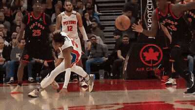A Basketball Player With The Number 12 On His Jersey Is Being Fouled GIF