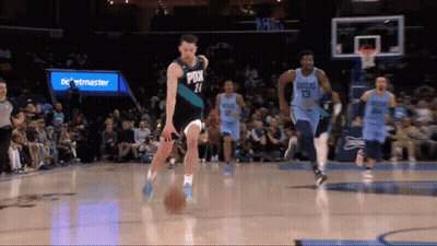 A Basketball Player With The Number 21 On His Jersey Dribbles The Ball GIF