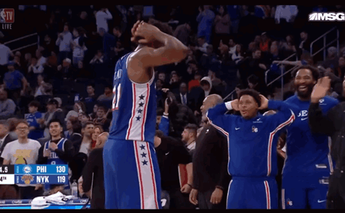 A Basketball Player With The Number 21 On His Jersey Stands In Front Of A Crowd GIF