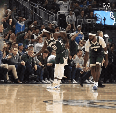A Basketball Player With The Number 21 On His Jersey Stands On The Court GIF