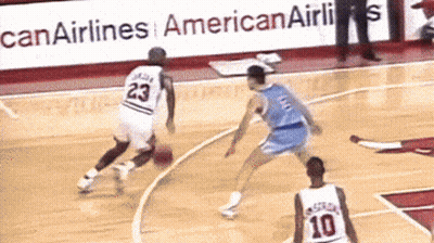 A Basketball Player With The Number 23 On His Jersey Dribbles The Ball GIF