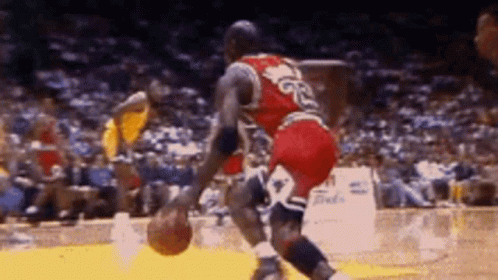 A Basketball Player With The Number 23 On His Jersey Is Dribbling A Basketball GIF