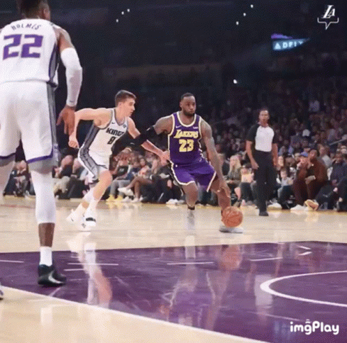 A Basketball Player With The Number 23 On His Jersey Is Dribbling The Ball GIF