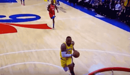 A Basketball Player With The Number 23 On His Jersey Is Jumping Into The Hoop GIF