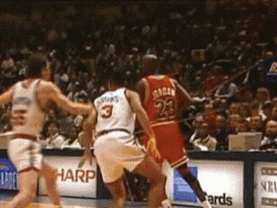 A Basketball Player With The Number 23 On His Jersey Is Playing Against Another Player . GIF