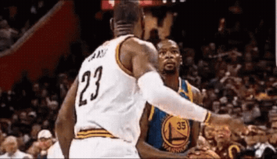 A Basketball Player With The Number 23 On His Jersey Is Standing Next To Another Basketball Player . GIF