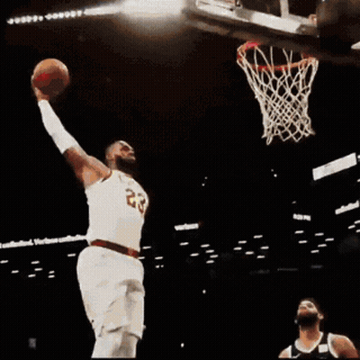 A Basketball Player With The Number 23 On His Jersey Jumps Into The Air GIF