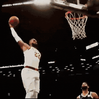 A Basketball Player With The Number 23 On His Jersey Jumps Into The Air GIF