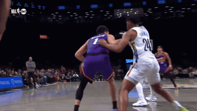 A Basketball Player With The Number 24 On His Jersey Tries To Block Another Player GIF