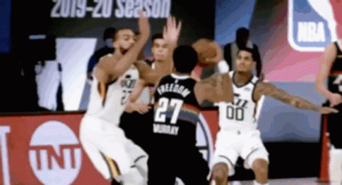 A Basketball Player With The Number 27 On His Jersey Tries To Get The Ball GIF