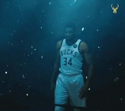 A Basketball Player With The Number 34 On His Jersey Is Standing In Front Of A Green Ball . GIF