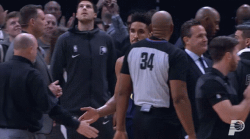 A Basketball Player With The Number 34 On His Jersey Shakes Hands With A Referee GIF