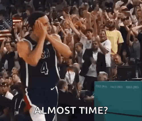 A Basketball Player With The Number 4 On His Jersey Is Standing In Front Of A Crowd Of People And Applauding . GIF