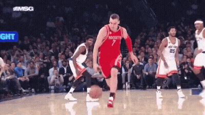 A Basketball Player With The Number 7 On His Jersey Is Dribbling A Basketball GIF