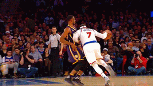 A Basketball Player With The Number 7 On His Jersey Is Playing Against Another Player GIF