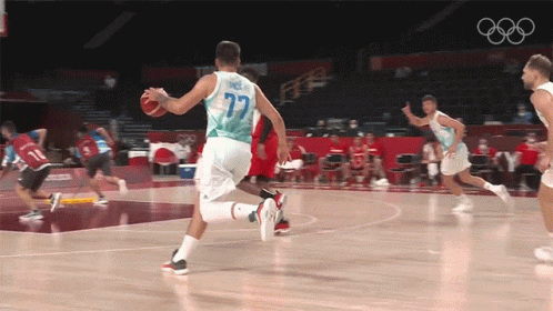 A Basketball Player With The Number 77 On His Jersey Is Dribbling The Ball GIF