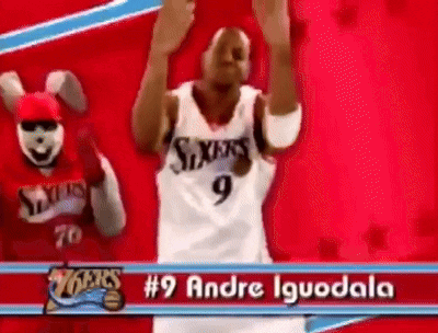 a basketball player with the number 9 on his jersey is dancing in front of a mascot .