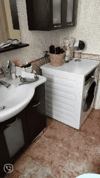 A Bathroom With A Sink And A Washer GIF
