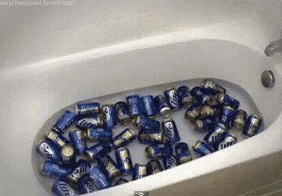A Bathtub Filled With Cans Of Miller Lite GIF