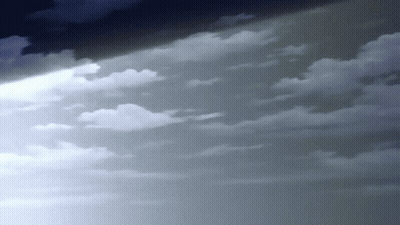 A Beam Of Light Is Shining Through The Clouds In The Sky . GIF