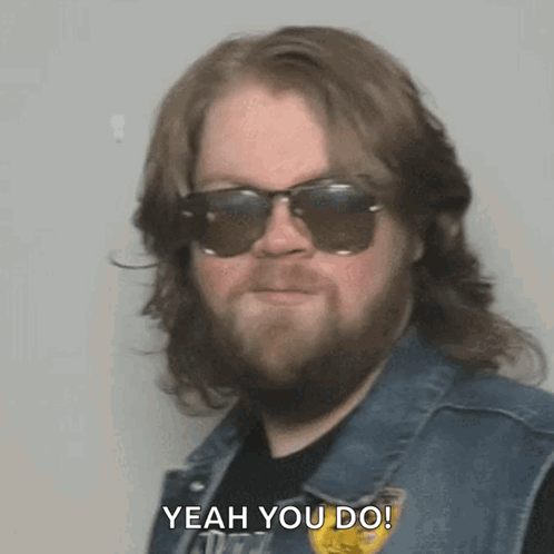 A Bearded Man Wearing Sunglasses And A Vest Says Yeah You Do . GIF