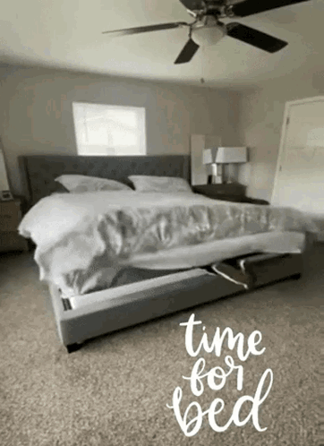 A Bedroom With A Bed And A Ceiling Fan And The Words Time For Bed Written On The Floor GIF