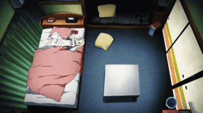 A Bedroom With A Bed And A Coffee Table And A Trash Can GIF