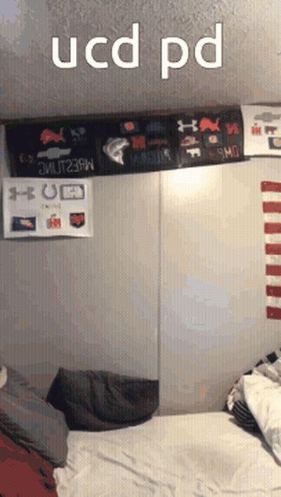 A Bedroom With A Bed And A Sign That Says Ucd Pd On It GIF