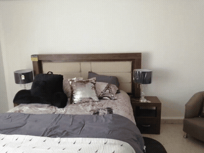 A Bedroom With A Bed And Two Lamps And A Pillow That Says Eiffel Tower GIF