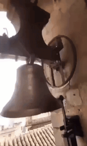A Bell Is Hanging From The Side Of A Wall GIF