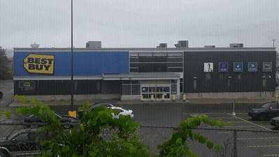 A Best Buy Store With Cars Parked In Front GIF