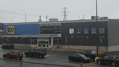 A Best Buy Store With Cars Parked In Front GIF