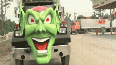 A Bic Truck Is Parked Next To A Truck With A Green Face On It GIF