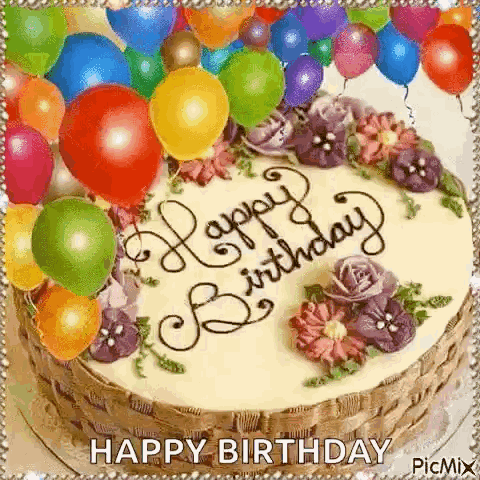 A Birthday Cake Decorated With Flowers And Balloons And The Words `` Happy Birthday '' Written On It . GIF