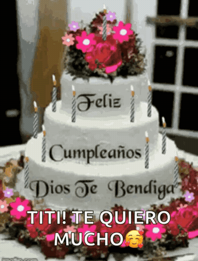 A Birthday Cake With Candles And Flowers On Top Of It GIF