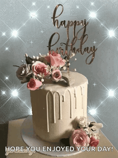 A Birthday Cake With Flowers And A Happy Birthday Sign GIF