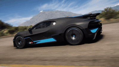 A Black And Blue Sports Car Is Driving On A Road With Mountains In The Background GIF