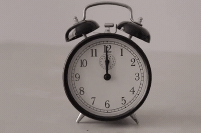 A Black And White Alarm Clock Shows That It Is Almost 5:00 GIF